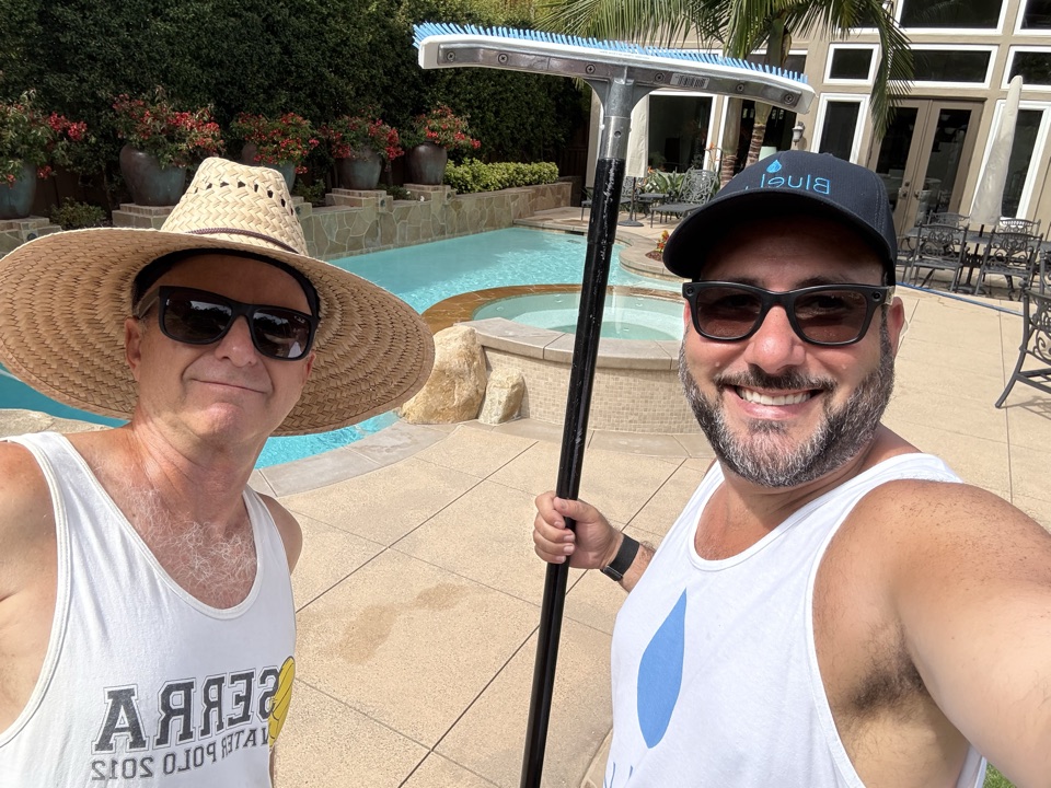 Sam Daoud working poolside with the retiring owner of the first pool-service business acquired by BlueLux